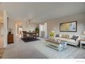 Bright living room with a spacious layout, neutral tones, plush carpeting, and a dining area at 465 Orchard Dr, Louisville, CO 80027