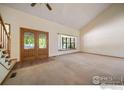 Spacious living room features neutral carpeting, vaulted ceiling, and a large double door at 4672 Kirkwood Ct, Boulder, CO 80301