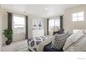 Bright bedroom with a view, featuring soft decor, a plush bed, and natural light from the windows at 4743 Hatcher Dr, Brighton, CO 80601