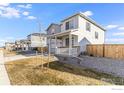 A view of the side of a two-story home with a covered front porch and neutral color palette at 4743 Hatcher Dr, Brighton, CO 80601