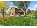 Large backyard with a patio, mature tree providing shade, and a well-manicured lawn at 4890 Lee Cir, Boulder, CO 80303