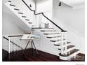 Elegant staircase with dark wood steps, white risers and banisters, and a sleek black handrail at 521 Hawthorn Ave, Boulder, CO 80304