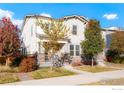 Charming two-story home featuring a covered porch, stone accents, mature trees, and a well-manicured lawn at 6041 N Orleans St, Aurora, CO 80019