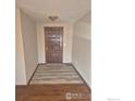 A freshly painted entryway with handsome wood floors and entry door at 614 Munson Ct, Berthoud, CO 80513