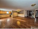 Open concept living space featuring wood floors, adjacent to the kitchen at 614 Munson Ct, Berthoud, CO 80513
