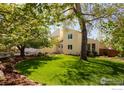 Lush backyard featuring a mature tree, a well-manicured lawn and a charming picket fence at 700 Linden Ave, Boulder, CO 80304