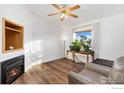 Inviting living room featuring hardwood floors, a cozy fireplace, and a bright window at 109 Ravine Pl, Lochbuie, CO 80603