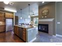 Open-concept living space featuring a kitchen island and fireplace at 1379 Charles Dr # E5, Longmont, CO 80503