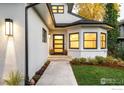 Inviting front entrance featuring a modern door with glass panels, stylish lighting, and professional landscaping at 1385 Kalmia Ave, Boulder, CO 80304