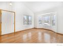 Bright living room with hardwood floors, vaulted ceilings, and large windows at 1577 Bain Dr, Erie, CO 80516