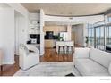 Open-concept living area with kitchen, workspace, and modern furnishings under a unique curved ceiling at 1700 Bassett St # 1303, Denver, CO 80202