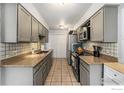 Functional kitchen showcasing ample cabinet space and modern appliances, complete with tiled backsplash at 2016 W 101St Ave, Thornton, CO 80260