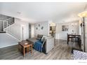 Bright and airy living room featuring gray walls and staircase with hardwood-style flooring and modern decor at 2016 W 101St Ave, Thornton, CO 80260