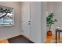 Bright entryway featuring a white front door, hardwood floors and a window at 2256 Watersong Cir, Longmont, CO 80504