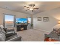 Cozy living room featuring comfortable seating, large windows, and a fireplace at 2509 Alto St, Fort Lupton, CO 80621