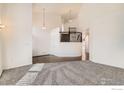 Spacious living room featuring high ceilings, carpeted floors, and stairs with decorative railing at 270 Terra Vista St, Brighton, CO 80601