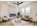 Bright living room with large windows, modern decor, a stylish fireplace, and comfortable seating area on wood floors at 2723 Bear Springs, Longmont, CO 80503