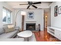 Cozy living room features a white brick fireplace and hardwood floors with a gray sectional sofa at 3630 Iris Ave # D, Boulder, CO 80301