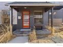 Inviting front porch featuring a vibrant orange door and convenient bench at 4464 N Raleigh St, Denver, CO 80212