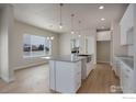 Modern kitchen with stainless steel sink in island, light countertops and ample natural light at 5755 Pintail Way, Frederick, CO 80504