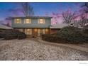 Charming two-story home with brick facade and light blue siding illuminated by dusk sky at 7169 Mount Meeker Rd, Longmont, CO 80503