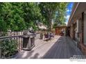 Back deck with a grill, table, chairs, shade trellis, and lush, mature trees at 7240 Clubhouse Rd, Boulder, CO 80301