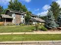 Stylish two story home featuring stone accents, solar panels, and verdant landscaping at 7240 Clubhouse Rd, Boulder, CO 80301