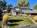 Well maintained two story home with a manicured lawn, stone accents and solar panels at 7240 Clubhouse Rd, Boulder, CO 80301