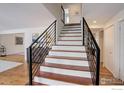 Stylish staircase with wood treads and white risers, complemented by sleek black railings at 7240 Clubhouse Rd, Boulder, CO 80301