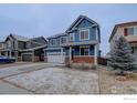 Charming two-story blue home with a two-car garage and red brick accents at 739 Graham Cir, Erie, CO 80516