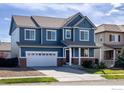 Charming two-story home showcasing a brick-accented facade, a well-manicured lawn, and an attached two-car garage at 739 Graham Cir, Erie, CO 80516