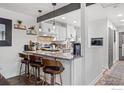 Stylish kitchen featuring bar seating, granite countertops, and modern white cabinetry at 8050 Niwot Rd # 58, Niwot, CO 80503