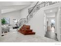 Bright entryway featuring elegant staircase with iron railing and views of living and dining areas at 1017 Azure Way, Louisville, CO 80027