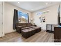 Comfortable living room featuring a plush brown sofa, natural light, and modern decor at 1059 Spartan Ave, Berthoud, CO 80513