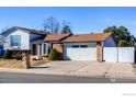 A charming home featuring brick and siding, a well-manicured lawn, and a convenient two-car garage at 1135 Fern St, Broomfield, CO 80020