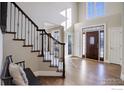 Bright foyer with hardwood floors, staircase with metal spindles, and a front door with decorative glass at 1321 Onyx Cir, Longmont, CO 80504