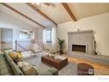 Spacious living room with vaulted ceilings, exposed beams, and a brick fireplace at 1507 Atwood St, Longmont, CO 80501