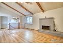 Bright living room with vaulted ceilings, exposed beams, and a brick fireplace at 1507 Atwood St, Longmont, CO 80501