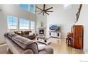 Bright living room featuring soaring ceilings, a fireplace, and hardwood floors at 18690 W 84Th Dr, Arvada, CO 80007