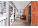 Inviting front porch featuring cozy wicker chairs, a brick exterior, and a wood deck at 2137 Mapleton Ave, Boulder, CO 80304