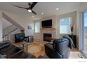 Comfortable living room featuring a stone fireplace, modern ceiling fan and comfortable leather furniture at 2397 Bristol St, Superior, CO 80027