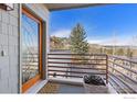 Charming balcony with mountain views, wood-trimmed window, metal railing, succulent planter, and patterned rug at 2690 Juilliard St, Boulder, CO 80305