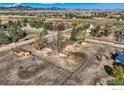 An aerial view of a home on a large property with mature trees and mountain views at 4025 Arleigh Dr, Berthoud, CO 80513