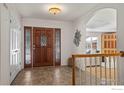 Entryway with decorative front door, tile flooring, and a view into the adjacent living space at 4862 Silver Sage Ct, Boulder, CO 80301