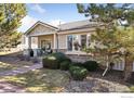 Charming home with a cozy front porch, manicured lawn and mature landscaping at 5019 Pasadena Way, Broomfield, CO 80023