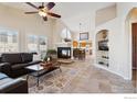 Bright and airy living room featuring a fireplace, tile floors and seamless access to the dining area at 5019 Pasadena Way, Broomfield, CO 80023