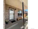 Inviting front porch with brick siding, bench seating, and decorative front door at 560 S 9Th St, Berthoud, CO 80513