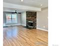 Spacious living room with hardwood floors and a stone fireplace, creating a cozy and inviting atmosphere at 560 S 9Th St, Berthoud, CO 80513