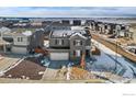 An aerial view of a two-story home with solar panels, a two-car garage, and a well-maintained neighborhood at 6233 Easton Ave, Frederick, CO 80504