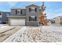 Two-story home with gray siding, white garage door, and a snow-dusted front yard in a residential neighborhood at 6233 Easton Ave, Frederick, CO 80504